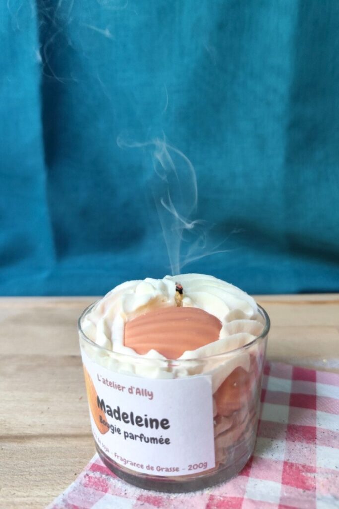 Bougie gourmande Madeleine de L'atelier d'Ally encore fumante après extinction, illustrant les conseils pour éteindre une bougie proprement.