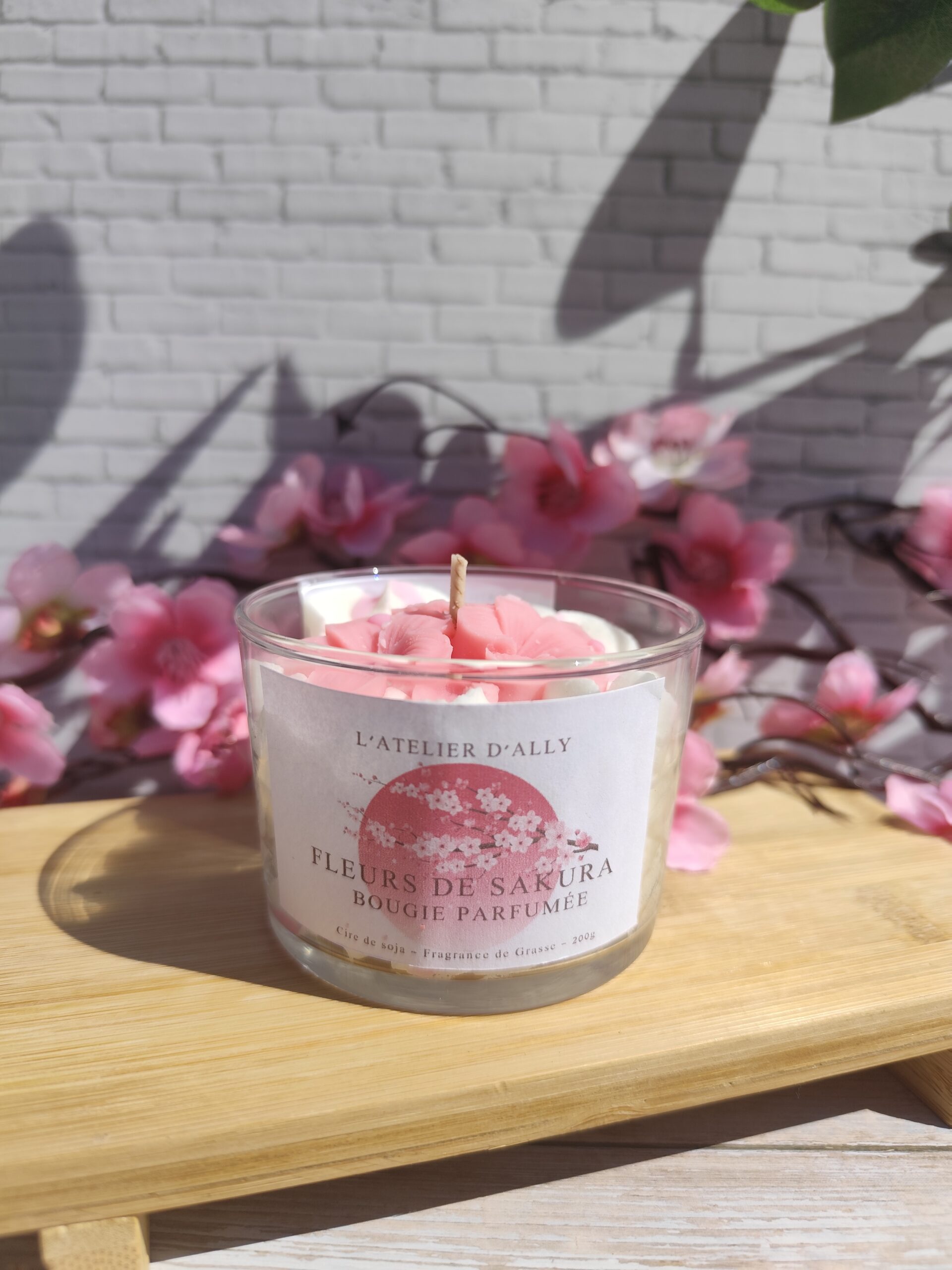 Bougie Fleurs de Sakura sans son pot en verre, décorée de fleurs en cire rose clair façon cerisier japonais