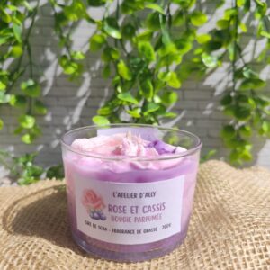 Bougie Rose & Cassis dans un contenant en verre, chantilly rose pâle ornée d'une rose en cire et de baies de cassis