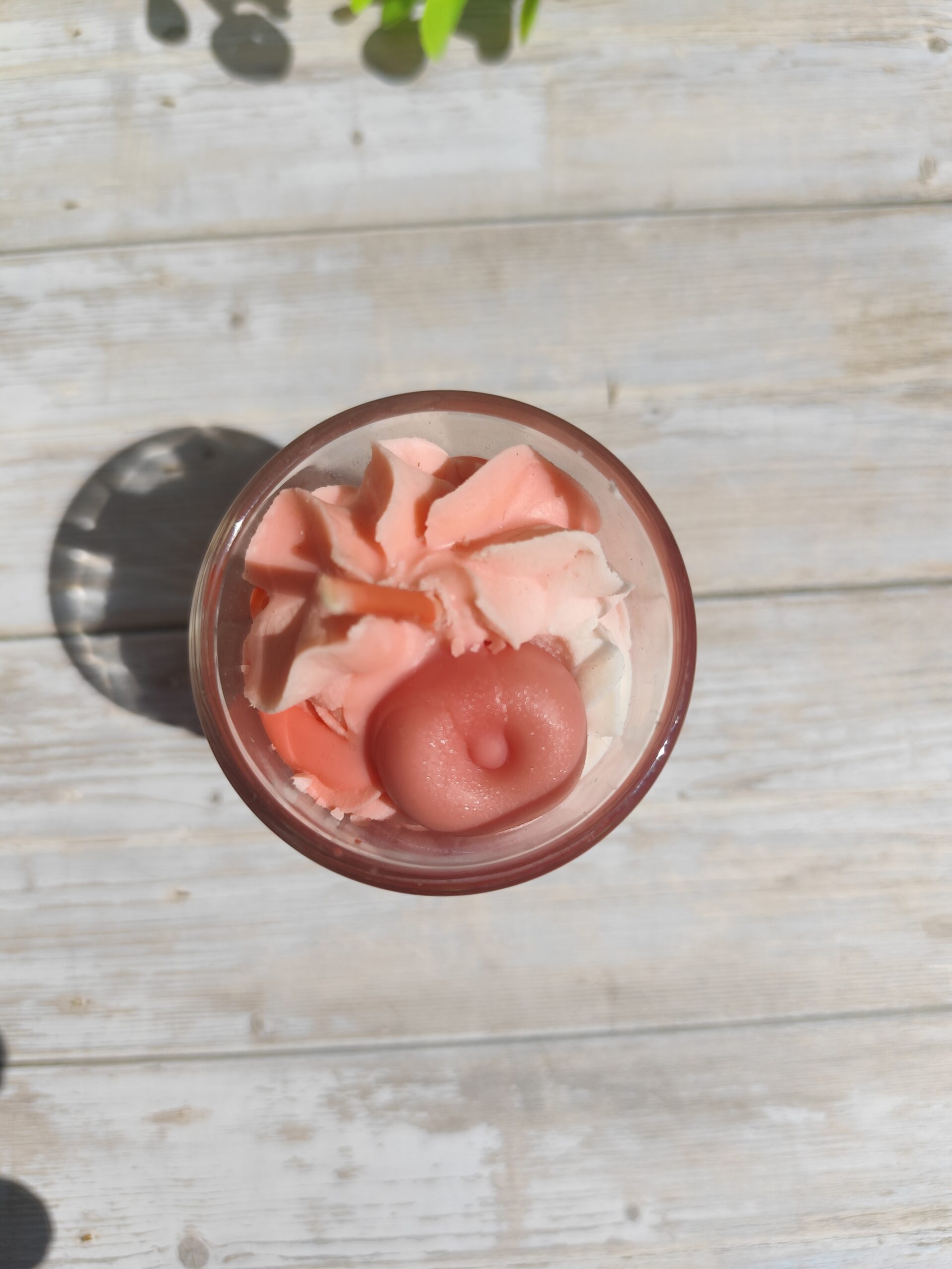 Mini bougie Pomme d'amour avec chantilly blanche, coulis rouge et pomme rouge en cire plongée au centre, dans un pot en verre