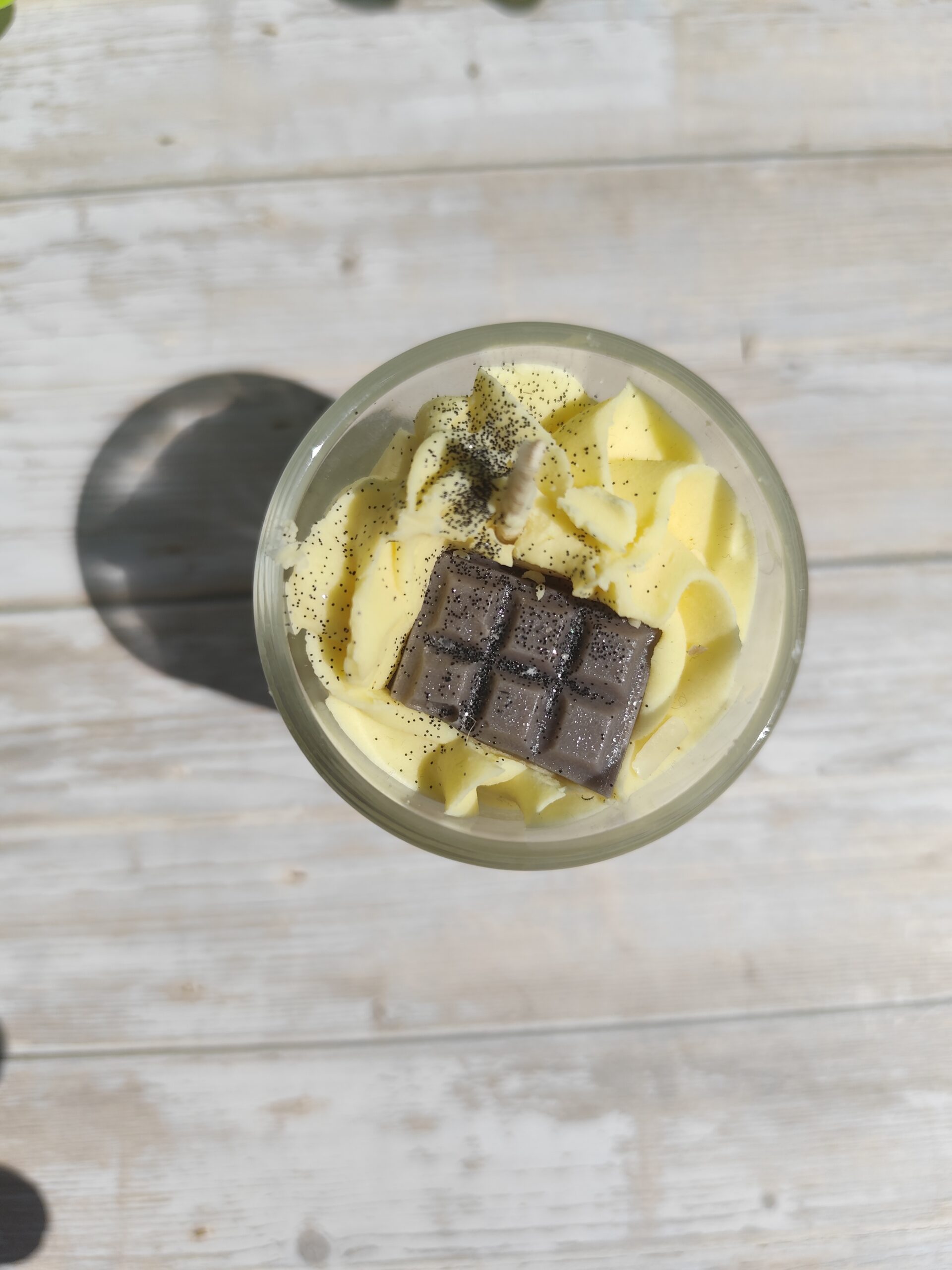 Mini bougie Vanille avec chantilly jaune parsemée de paillettes noires et mini tablette de chocolat en cire, dans pot en verre