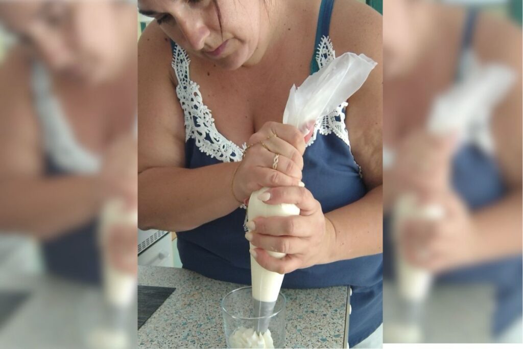 Artisane de L'atelier d'Ally en train de créer une bougie gourmande parfumée à la main avec poche à douille.