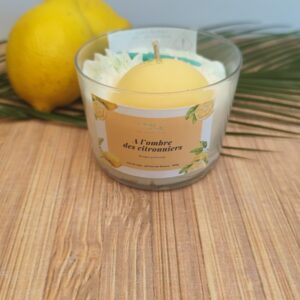 Création parfumée À l'ombre des citronniers avec citron en cire, chantilly blanche et décor citronné, mise en scène avec un citron frais.