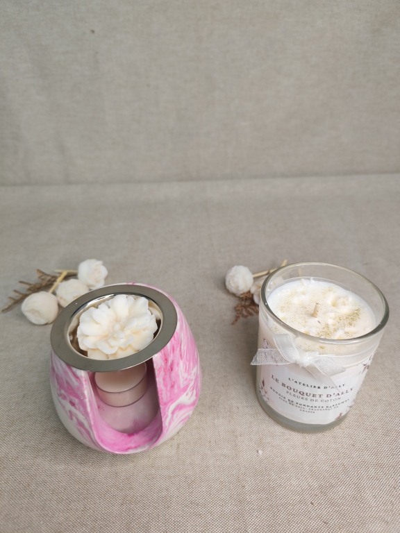 Bougie Bouquet d'Ally Fleurs de Coton accompagnée de fleurs fondantes parfumées utilisées dans un brûleur.