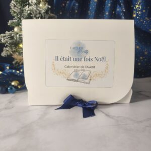 Calendrier de l'Avent fondants parfumés Il était une fois Noël, coffret blanc avec illustration de livre ouvert et ruban bleu.